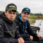 Dva mlada feeder ribolovca uz jezero, jedan nezadovoljan, drugi nasmiješen, prikazuju najčešće situacije koje živciraju ribolovce